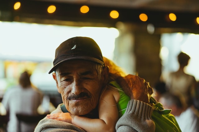 Großvater trägt sein Enkelkind